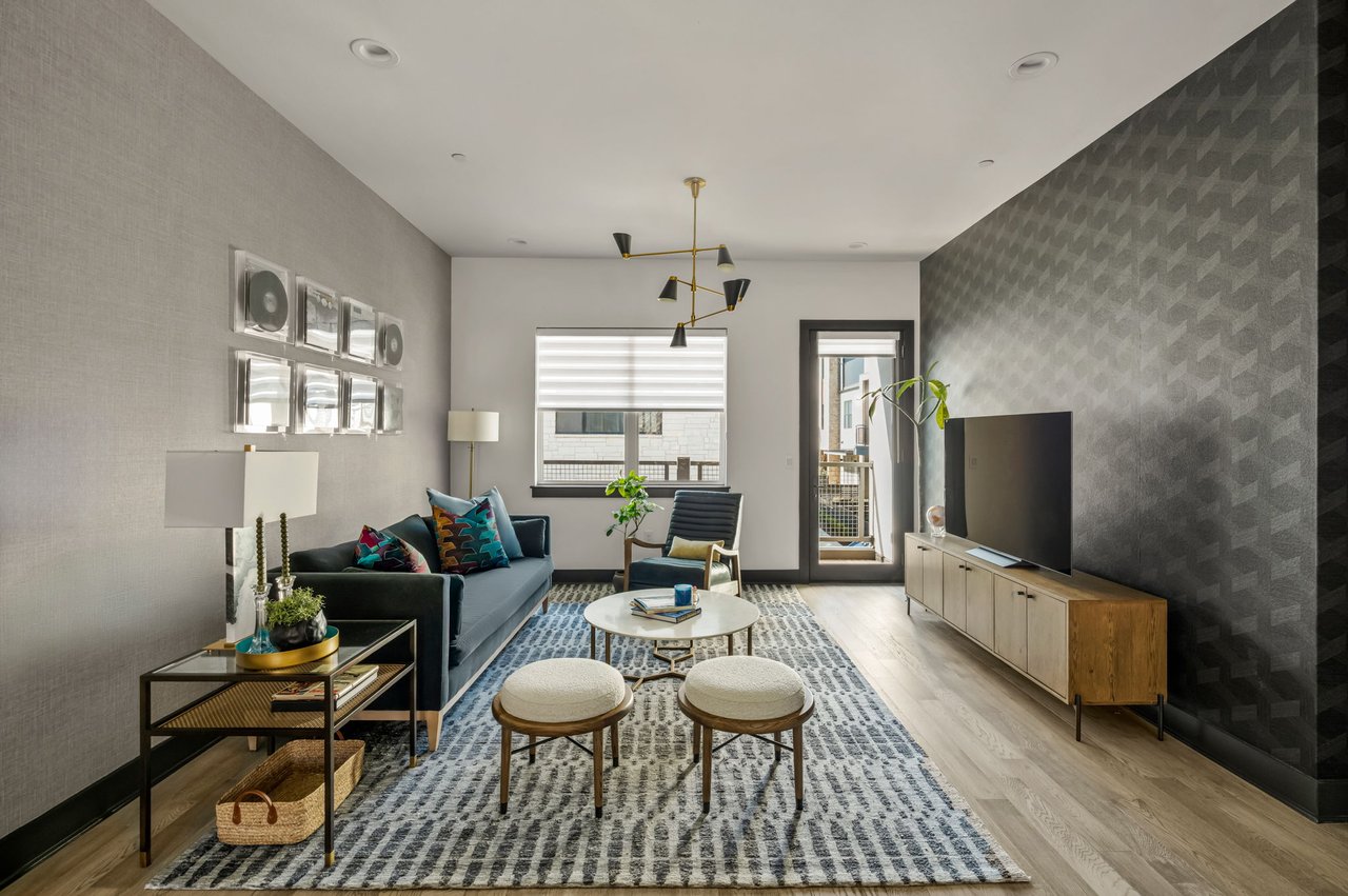 Living room at 4507 Unity Circle in The Grove, Austin, with a geometric wallpaper accent wall and custom media console, designed by Ashley Walker Designs.