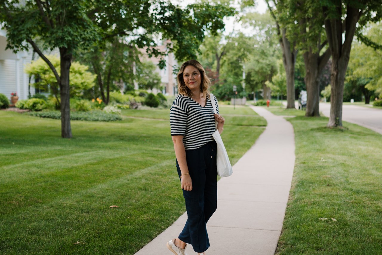 Cait Berry walking through a mature tree-lined Madison-area neighborhood.