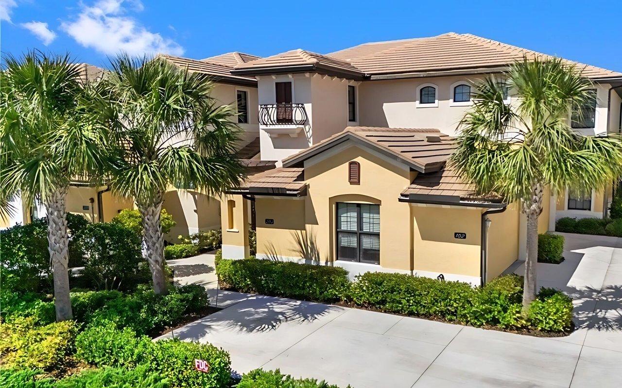 Savona residences with tan stucco facades, tiled roofs, palm trees, and landscaped walkways.