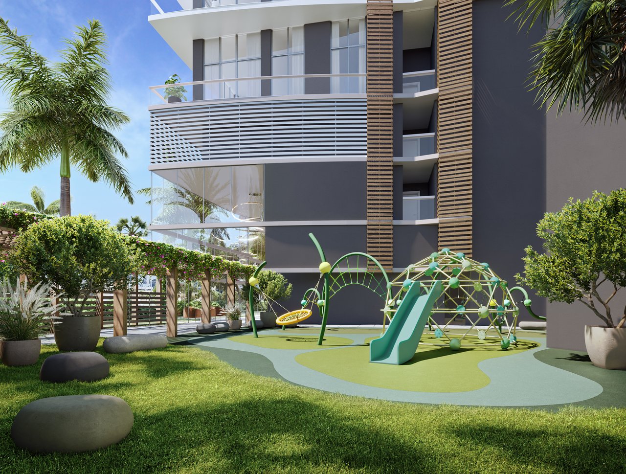 Modern residential building beside a landscaped playground with green slides and climbing equipment.