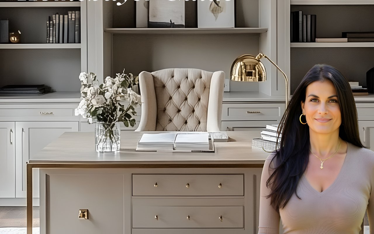 Woman with long dark hair beside a built-in desk and bookshelves.