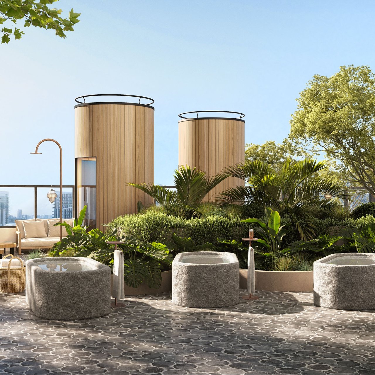 Rooftop terrace with round stone soaking tubs, tropical planting, and lounge seating.