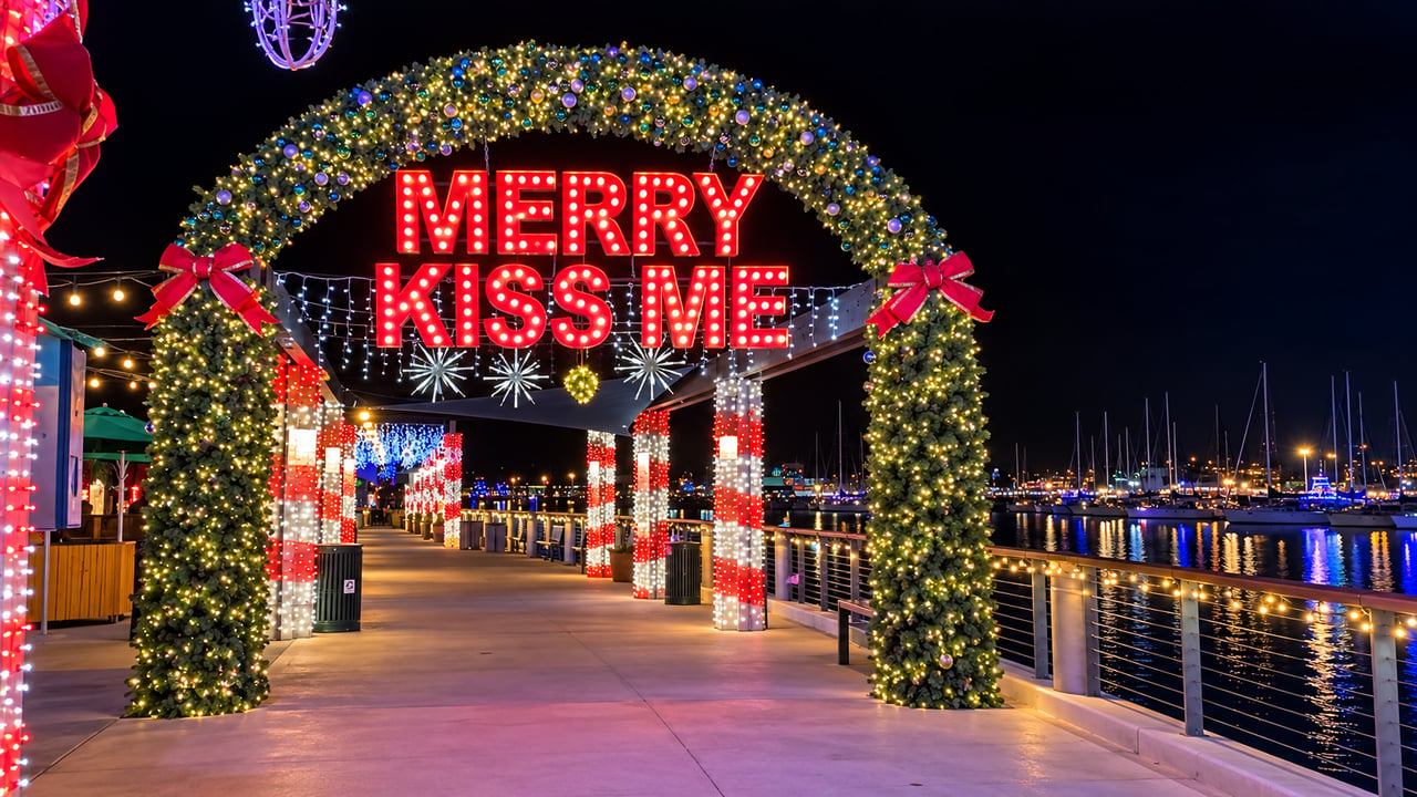 Merry Kiss Me holiday light arch on the Dana Point Harbor waterfront at night