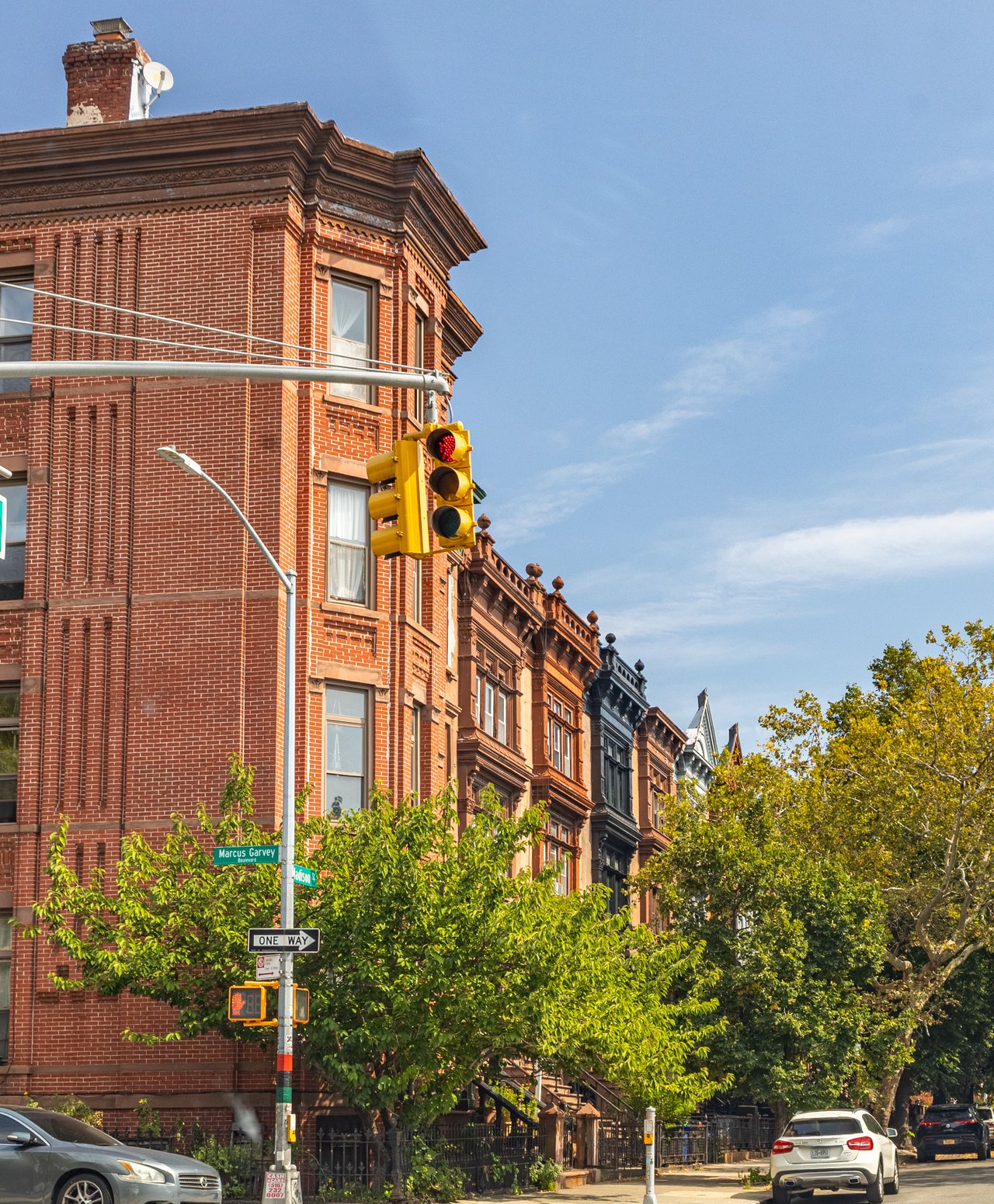Albany Avenue in Crown Heights, Brooklyn, featuring historic Queen Anne townhouses, brick residences, limestone properties, multifamily homes, and traditional residential architecture near Eastern Parkway. Explore Albany Avenue real estate, the Crown Heights North III Historic District, historic row houses, and townhouse sales with The Parviz Team at Compass, led by Parviz Latipzoda.