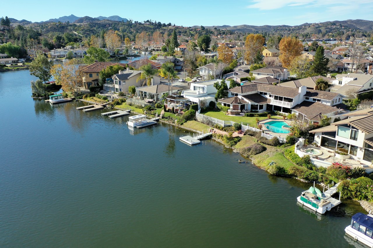 Aerial view of Toluca Lake waterfront homes, docks, boats, and a pool.