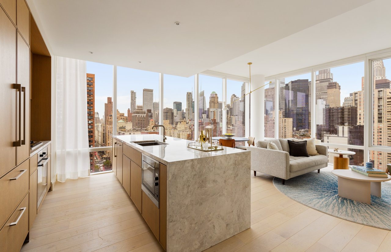 Open-plan kitchen and living room with floor-to-ceiling windows overlooking the city skyline.