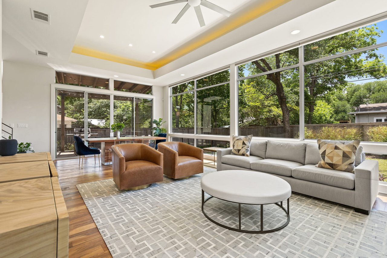 Screened porch with a wood beam ceiling and a wall of windows at 34 Margranita Crescent, Tarrytown, Austin, TX.