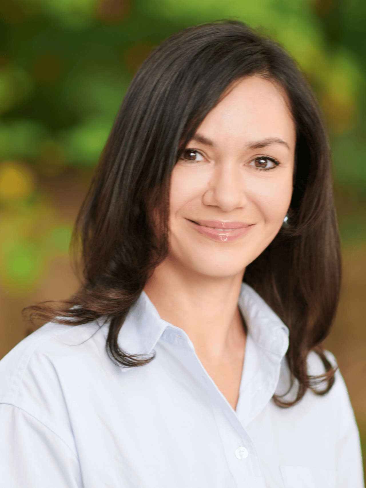 Mila Bobu in a light blue collared shirt, with long dark hair.