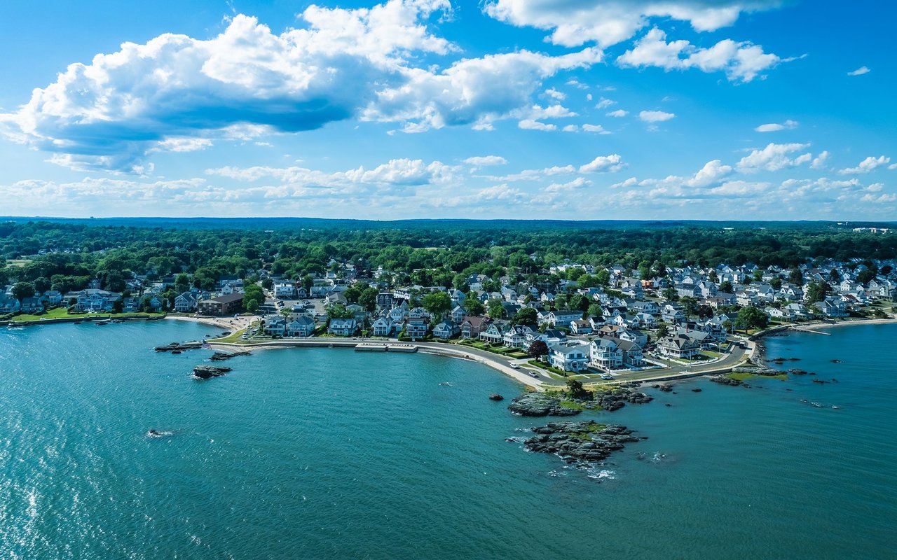 Aerial view of Milford’s coastal neighborhood, shoreline homes, and rocky outcrops.