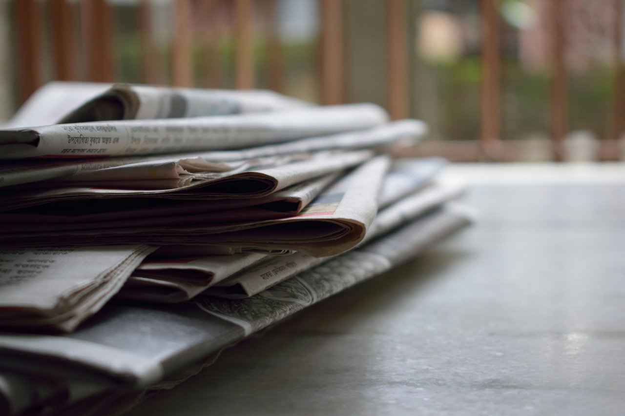 a pile of newspapers on a desk