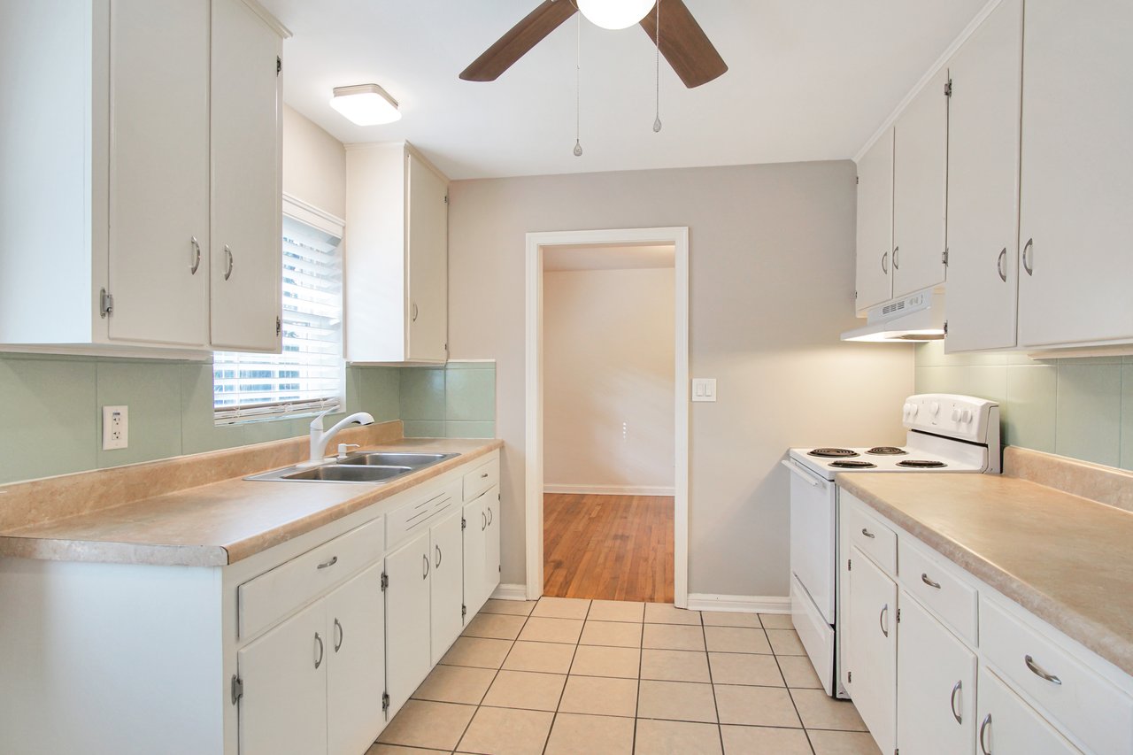 A kitchen featuring a ceiling fan above and a sink, showcasing a clean and functional cooking space.