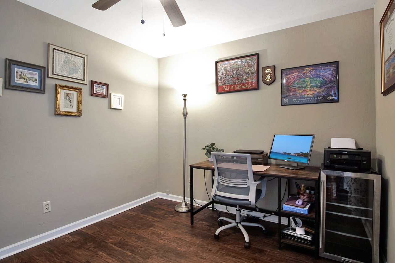 A well-organized home office featuring a desk, chair, and framed pictures adorning the walls.