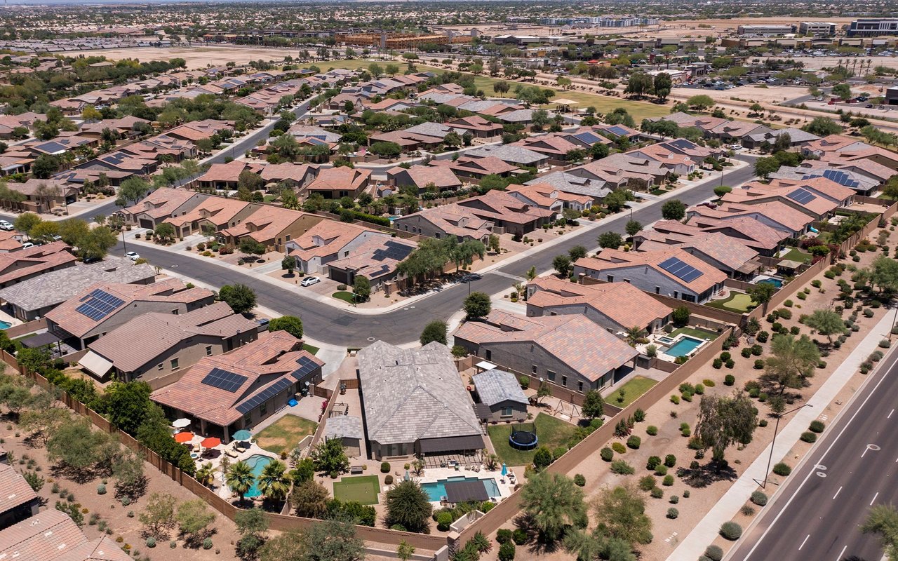 Aerial view of Goodyear homes with solar panels, desert landscaping, and backyard pools.