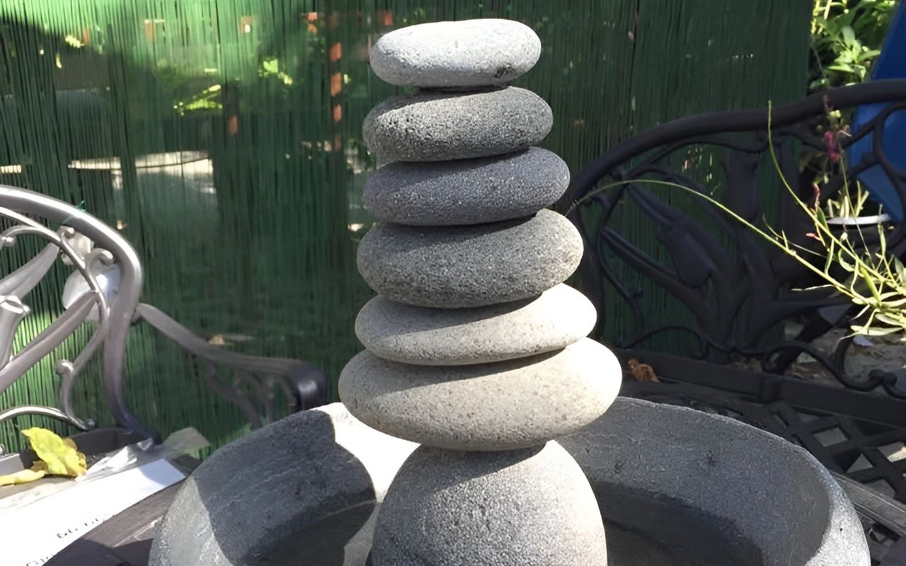 A tower of smooth gray stones balanced on an outdoor patio.
