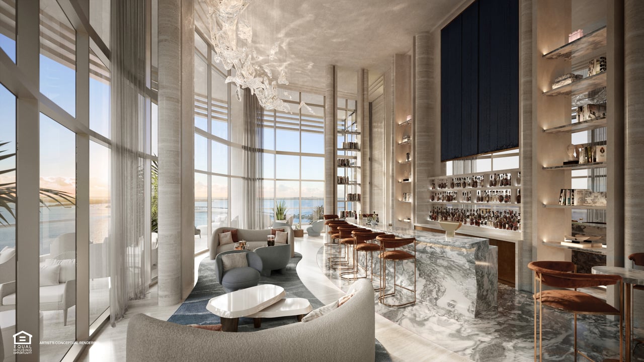 Luxury lounge and bar with marble counters, sculptural chandeliers, and floor-to-ceiling windows overlooking the water.