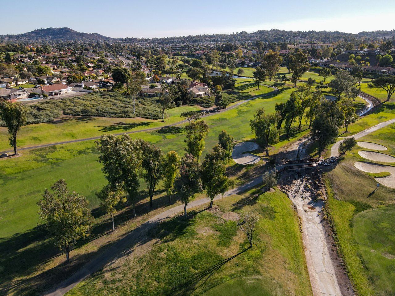 Aerial view of a Rancho Bernardo golf course bordered by homes and rolling hills.