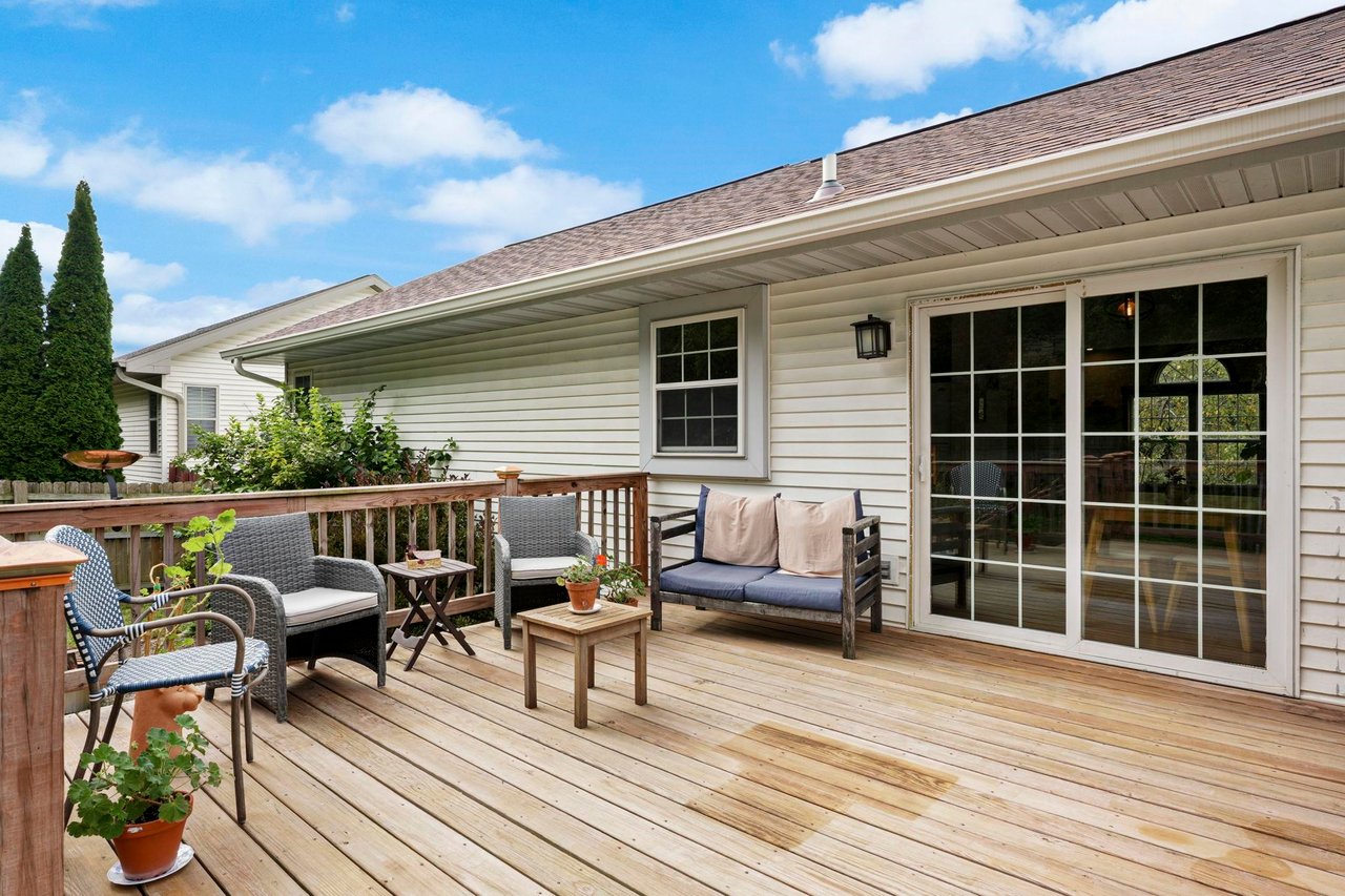 An asphalt shingle roof and gutter above the back deck of a Madison-area home on a clear day.