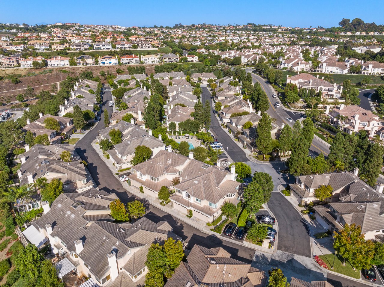 Aerial view of a coastal South Orange County HOA community with Mediterranean homes and mature landscaping.