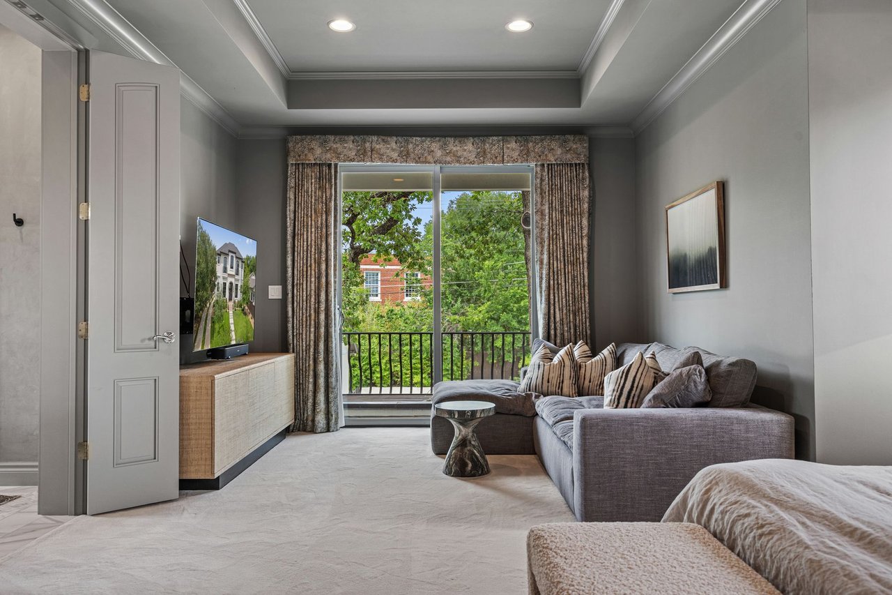 Primary suite sitting area with a private balcony and tree-top views, furnished by Ashby Collective, at 2600 Westover Road in Tarrytown, Austin.