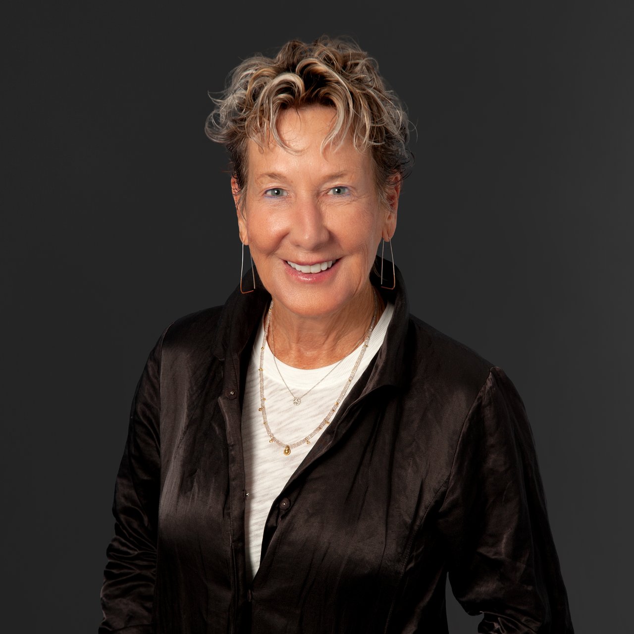 Christian Downer smiling in a black jacket and white shirt.