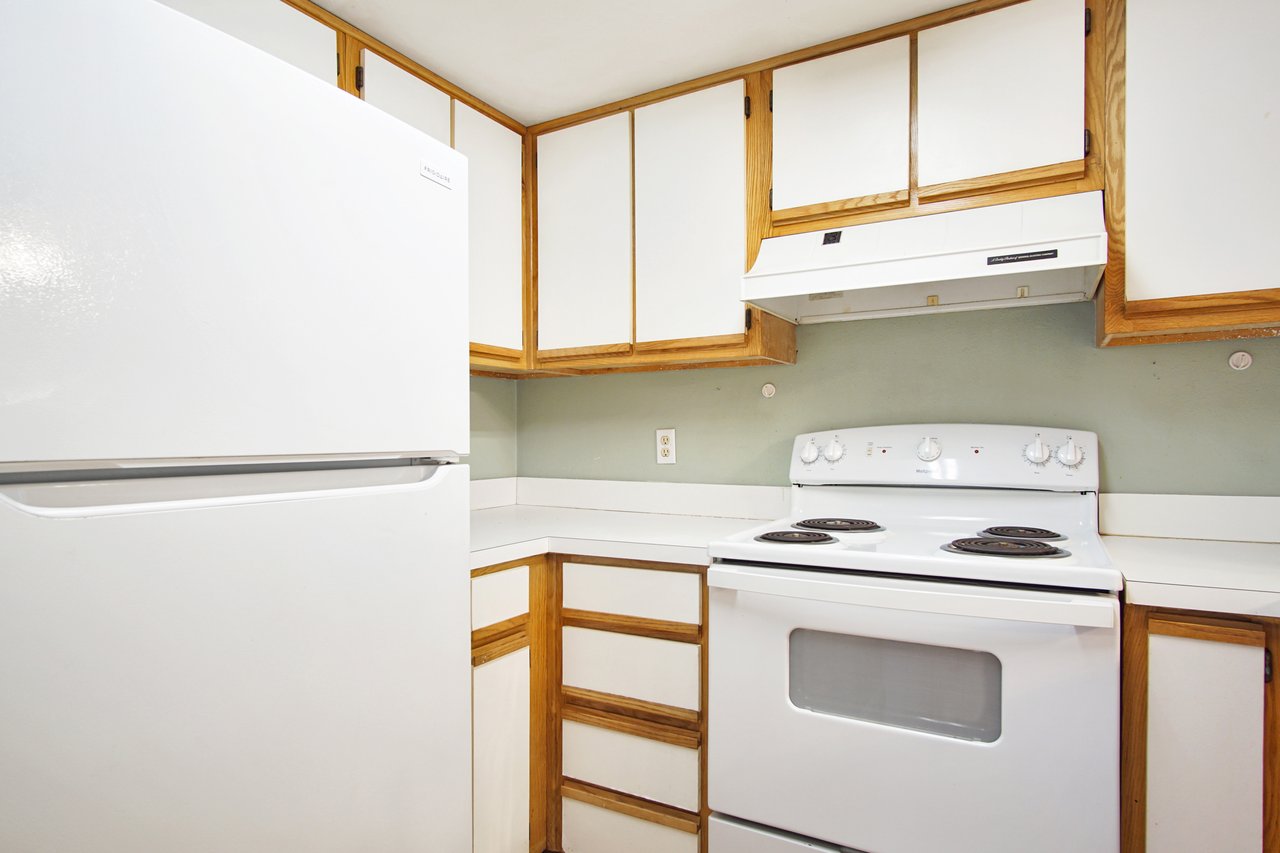 A white refrigerator stands prominently in a modern kitchen, complementing the overall decor and functionality of the space.