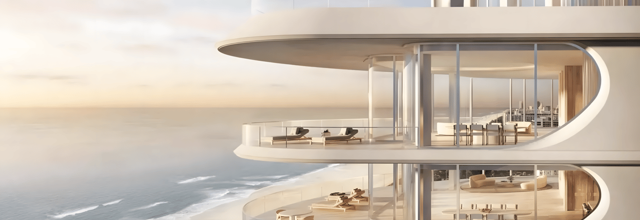 Modern oceanfront building with curved glass balconies overlooking the water.