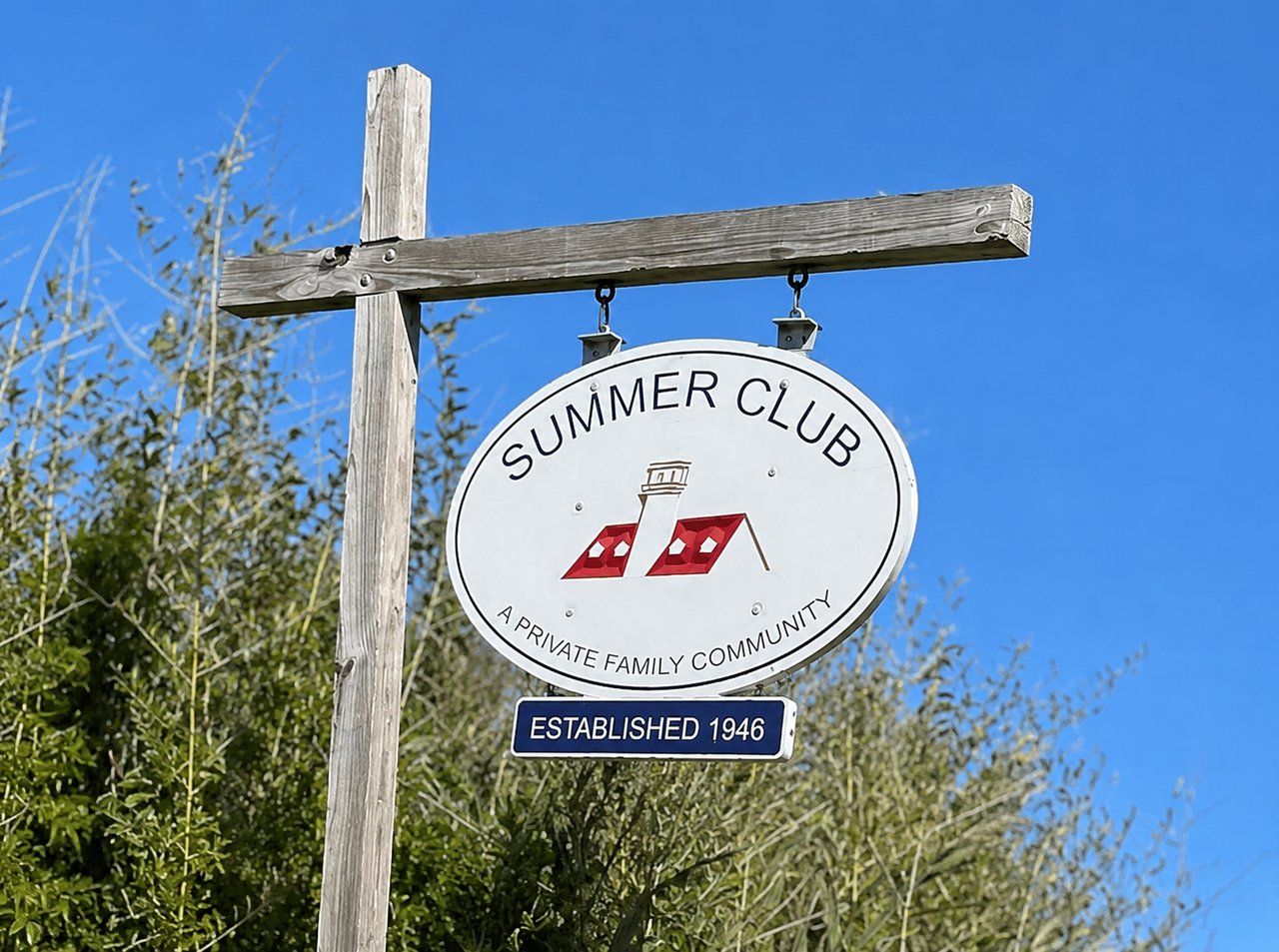 Summer Club community sign with a lighthouse emblem and an Established 1946 plaque.