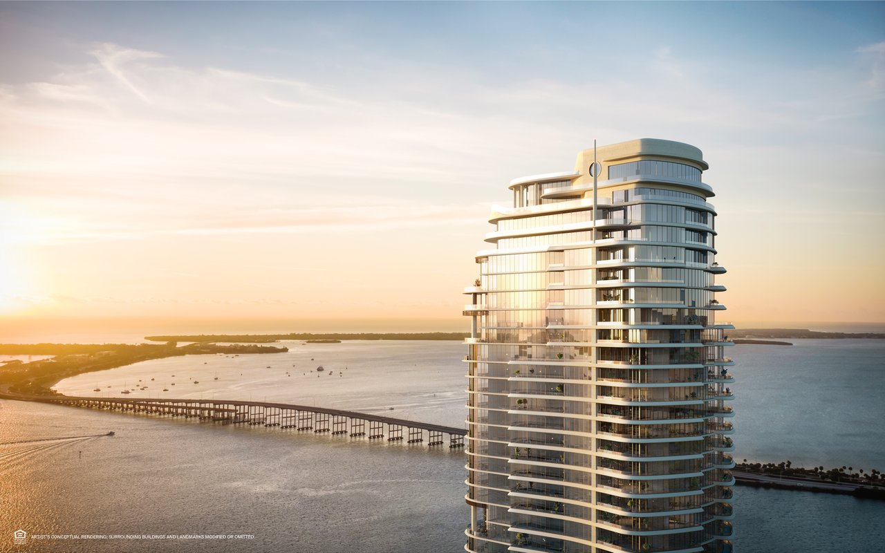 St. Regis Residences tower beside Biscayne Bay at sunset, with a bridge crossing the water.