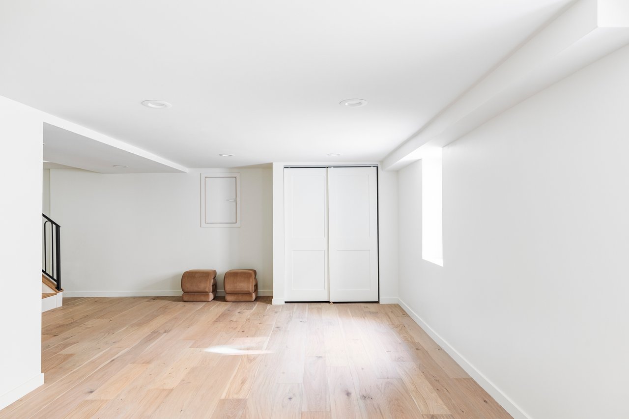 Basement with hardwood floors and a closet