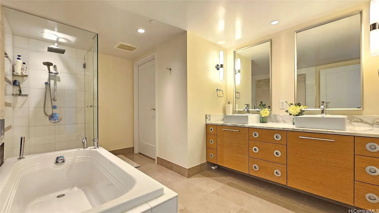 Spacious bathroom with a soaking tub, glass shower, and long double-sink wood vanity.