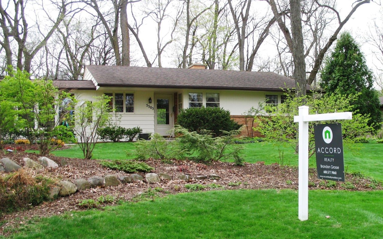 Single-story house with a landscaped lawn and Accord Realty sign in the front yard.