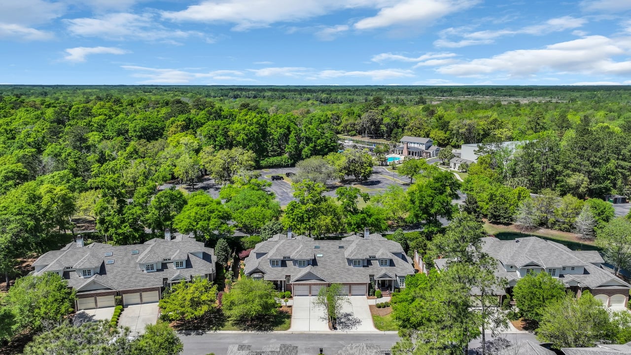 Aerial view of Harbor Club Villas, with attached homes, tree-lined grounds, and a community pool.