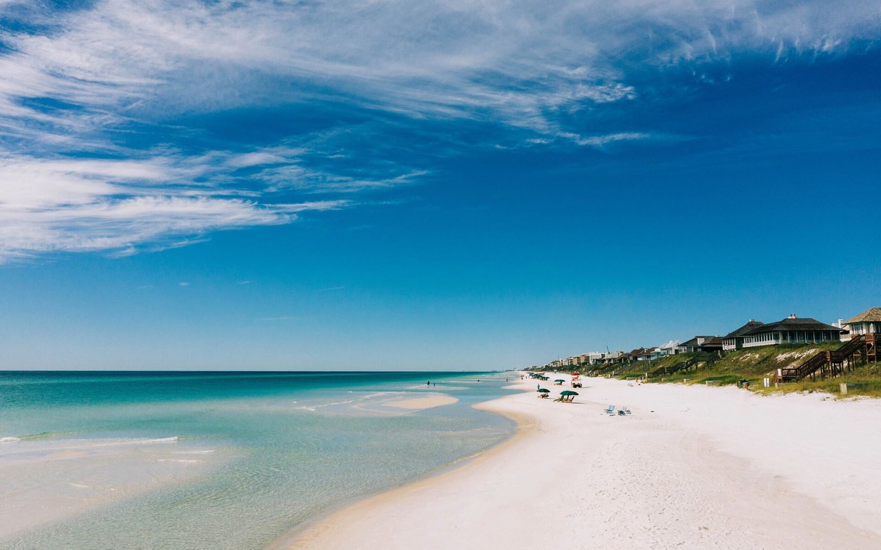 Bonita Beach shoreline with turquoise water, white sand, and beachfront homes.