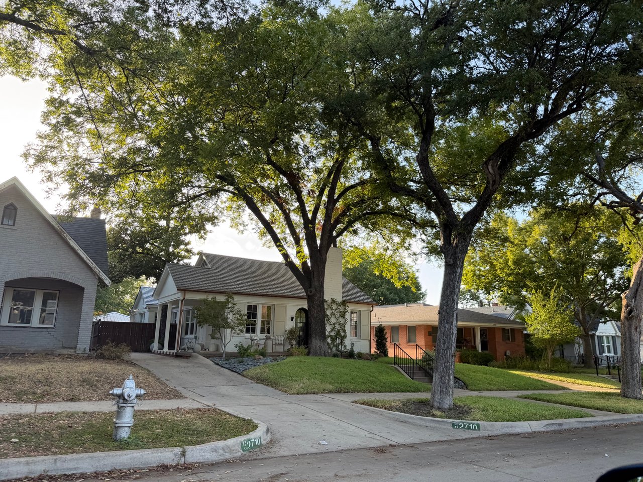 Ryan Place homes beneath mature trees, with front porches and sidewalks along a quiet residential street.