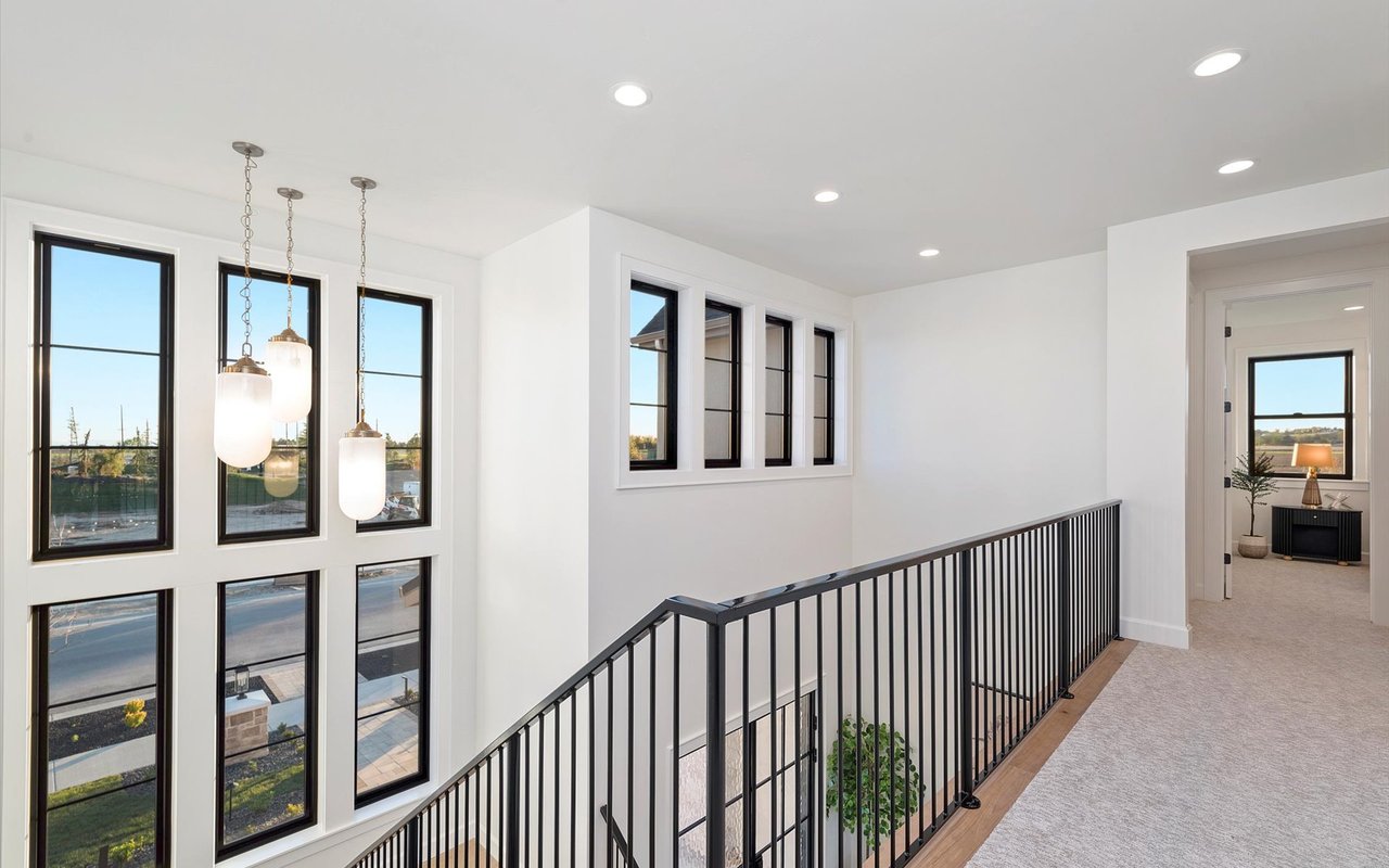View from the top of the stairs overlooking the black metal railing and foyer