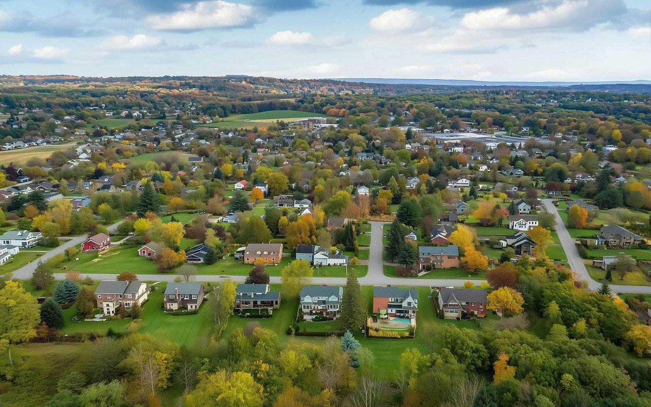 Aerial view of Norwalk homes and tree-lined streets amid autumn foliage.