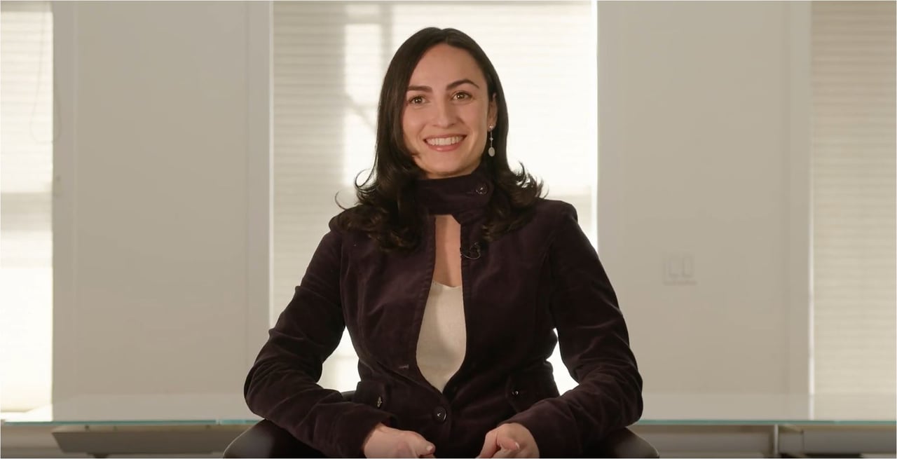 Sandra Levykh seated and smiling in a dark jacket.