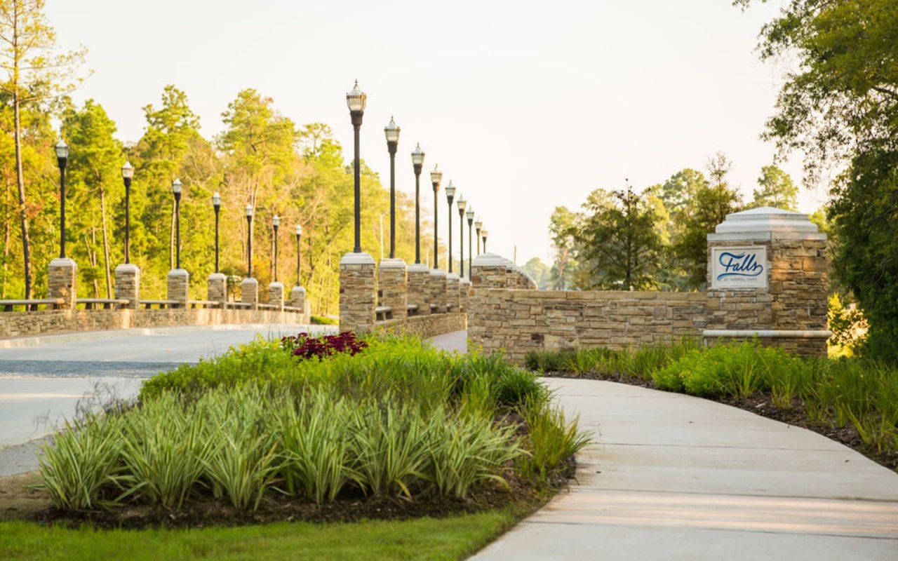 Stone bridge entrance with decorative lighting at The Falls at Imperial Oaks in Spring Texas