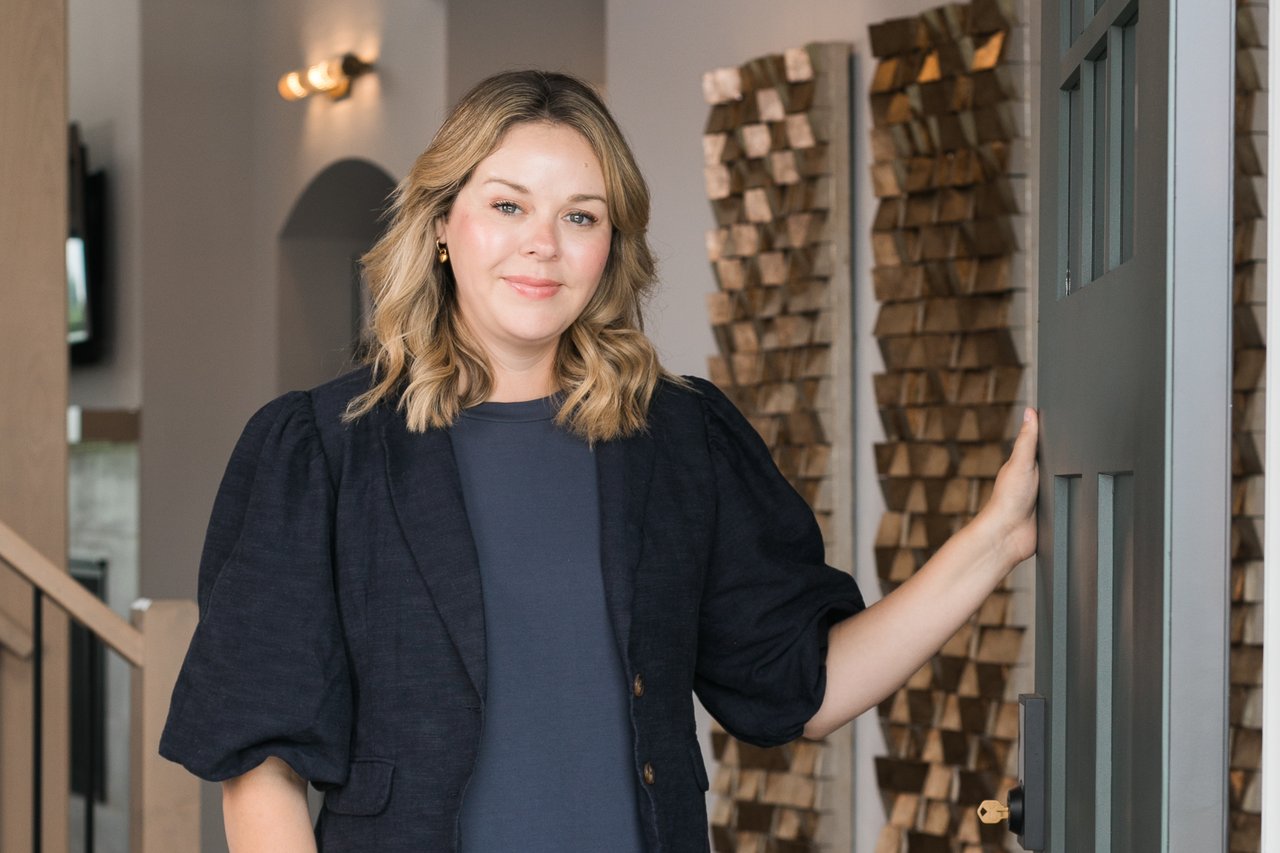 Madison-area Realtor Cait Berry inside a newly built home, representing her work helping two generations of one family relocate from Chicago and purchase neighboring homes in Verona, Wisconsin.