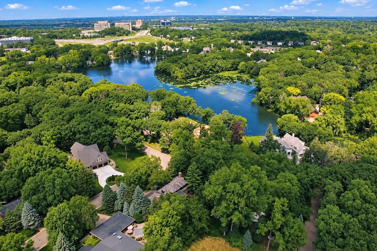 Aerial view of the Indian Hills neighborhood in Edina, Minnesota, showing Arrowhead Lake, mature trees, residential streets, and neighborhood homes. .