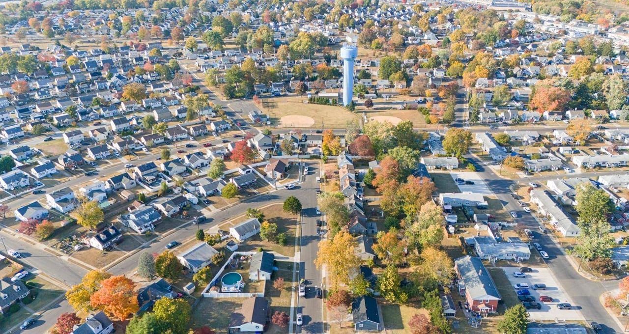 Bellmawr neighborhood with autumn trees, a water tower, and sports fields.
