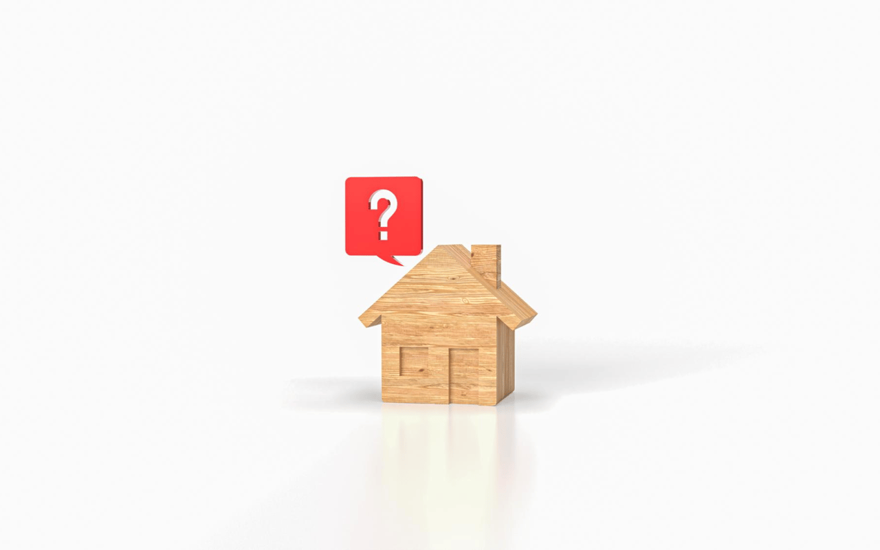 Wooden house model beneath a red question-mark speech bubble.