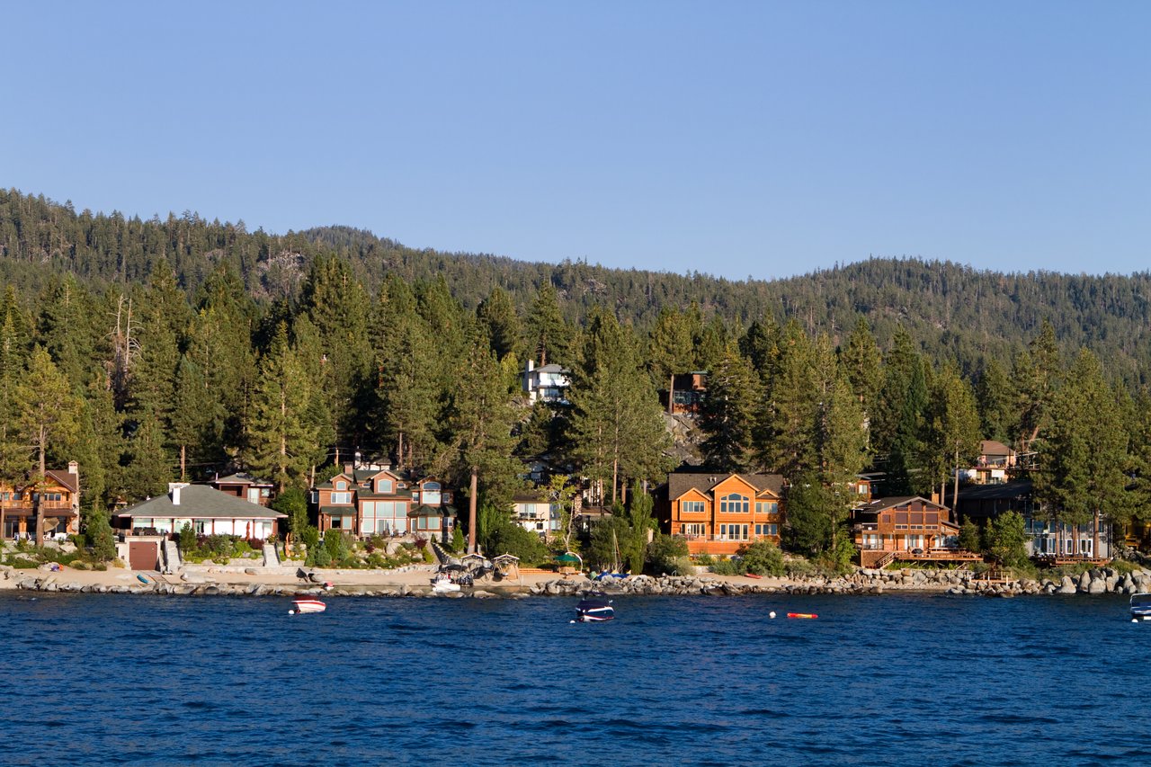 Aerial view of Lake Tahoe homes near the shoreline with mountain backdrop – 2025 real estate trends