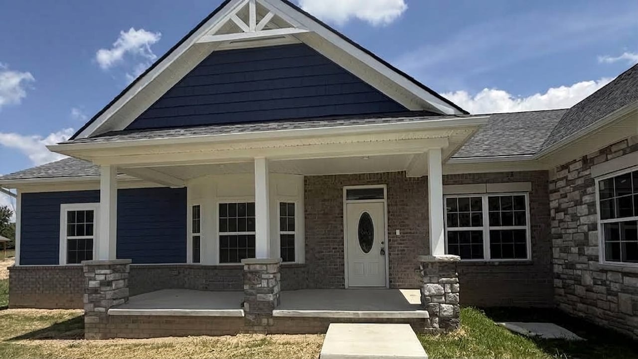 Home exterior with blue siding, stone accents, and a covered front porch.