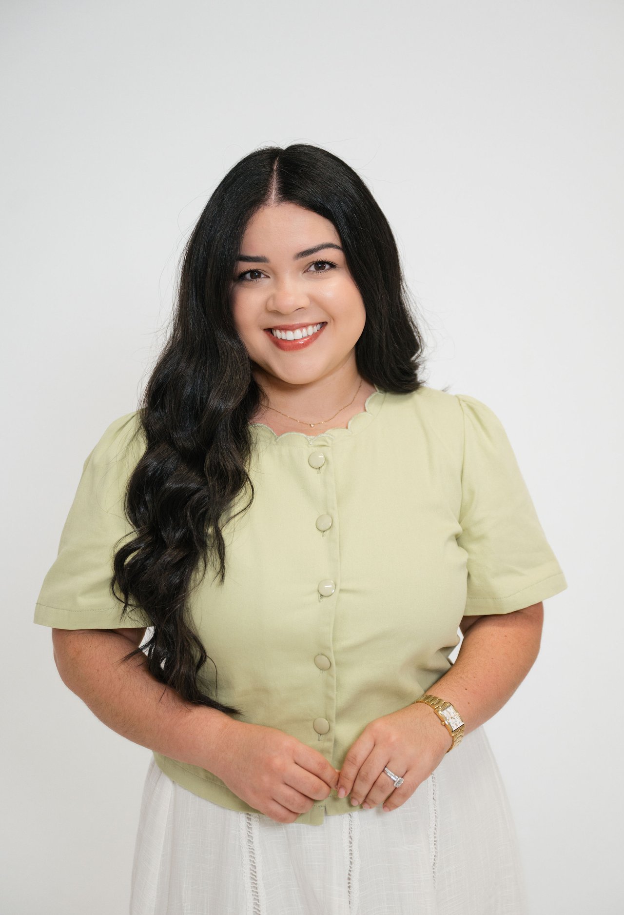 Nellymar Albelo smiling in a pale green blouse against a light background.