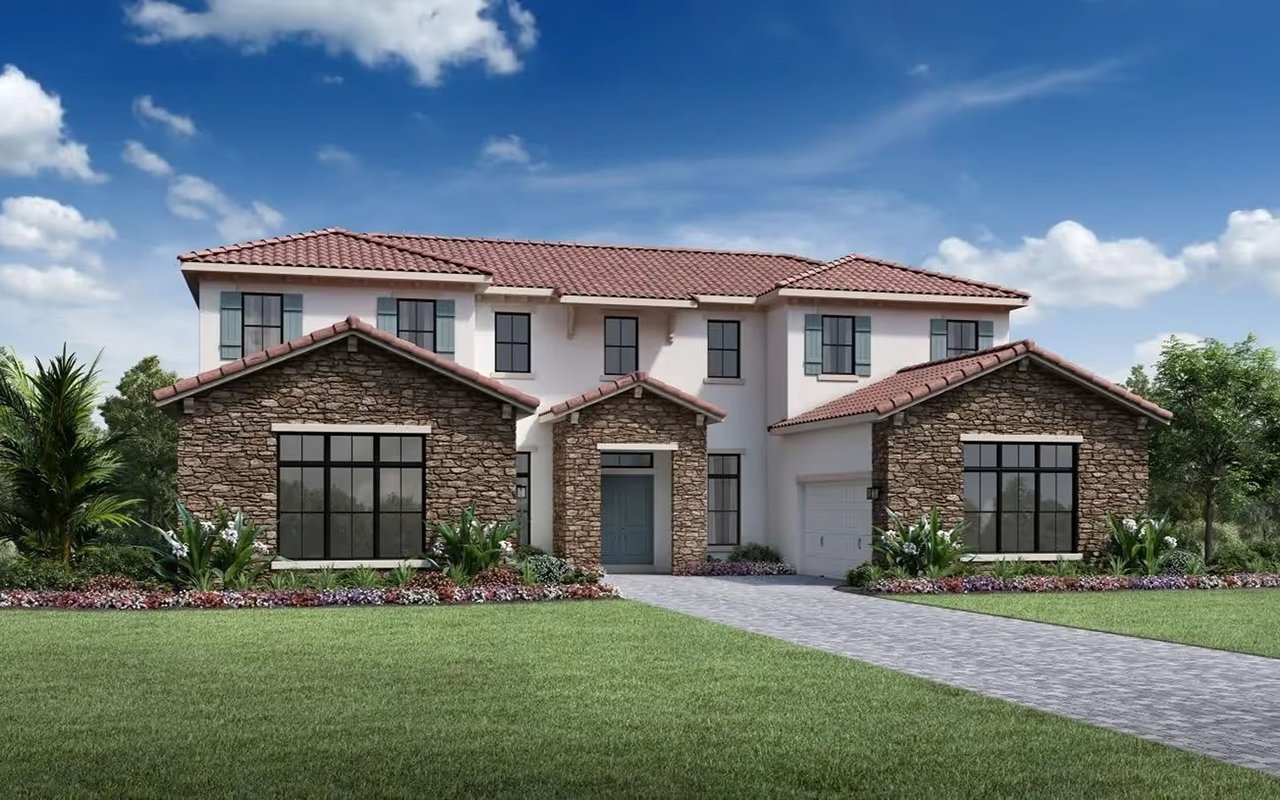 Two-story home with a stone facade, red tile roof, and landscaped front lawn.