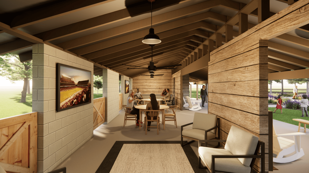 Community lounge with exposed timber beams, communal tables, and an open view to landscaped grounds.