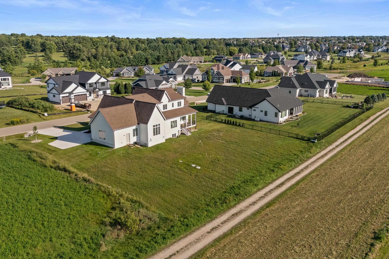 A sprawling luxury estate in Sun Prairie featuring custom stone architecture, extensive landscaping, and a large private driveway.
