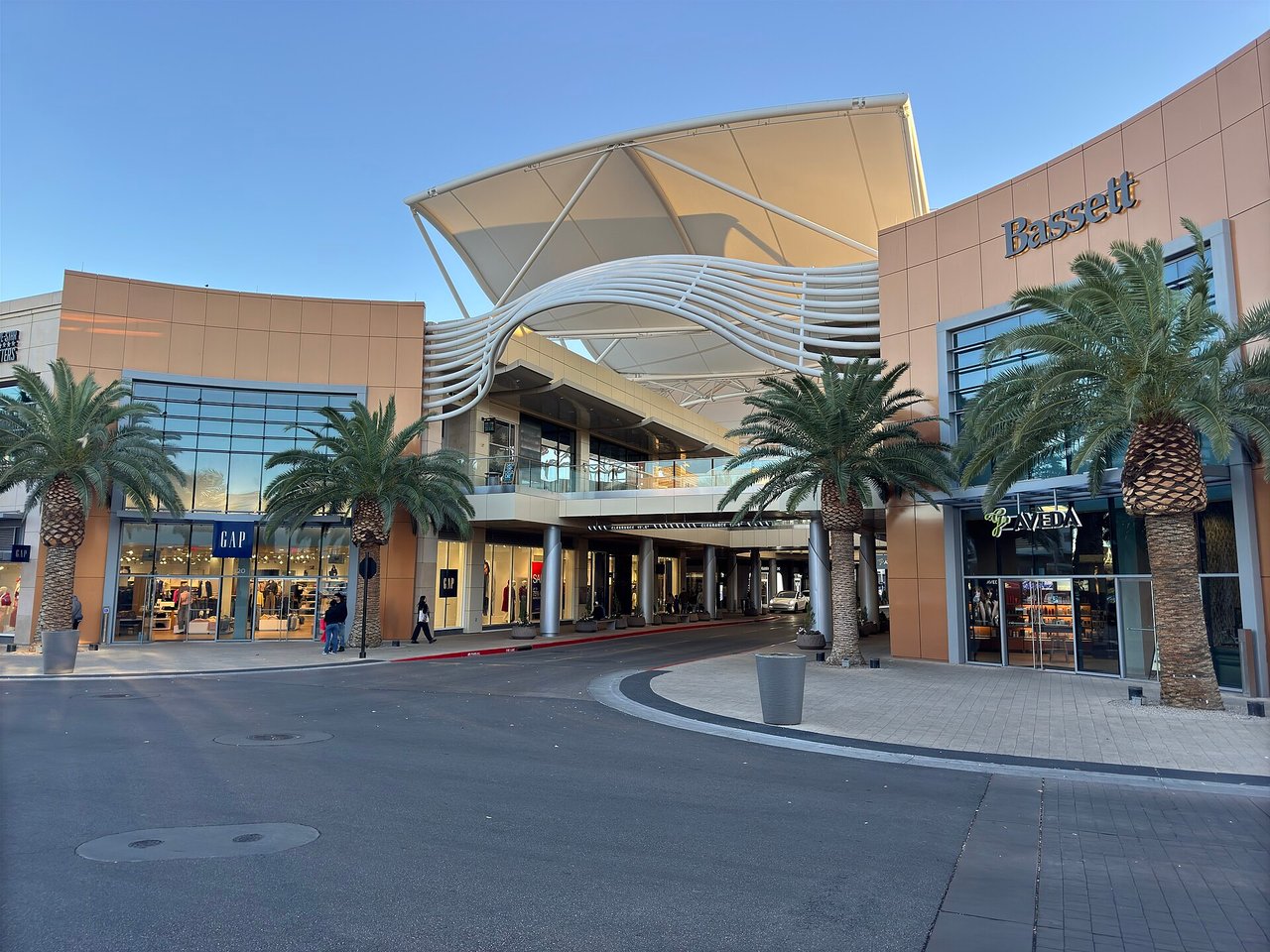 Downtown Summerlin shopping center entrance with Gap and Bassett storefronts, palm trees and a white canopy structure in Las Vegas