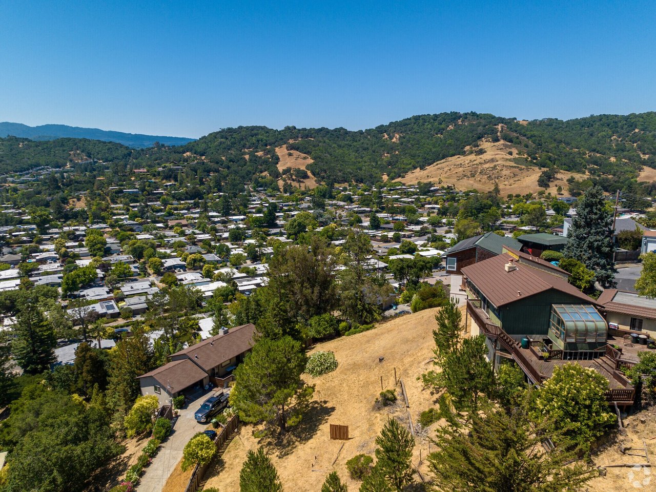 Aerial view of Terra Linda homes, wooded hills, and dry grassy slopes.